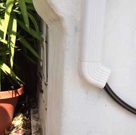 We just ran the hose up into a downspout to hide it.